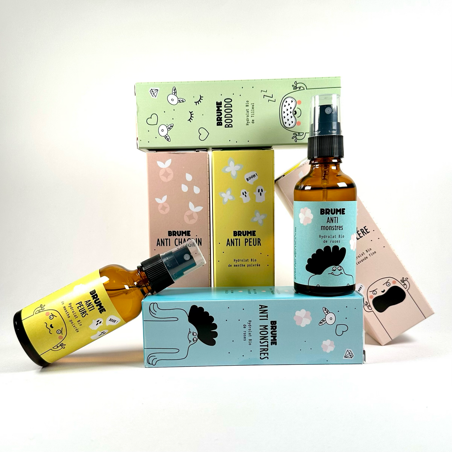 Image de la Collection Complète de Brumes à Base d'Hydrolat Bio, disposée de manière artistique, mêlant Packagins et Flacons, sur fond neutre.