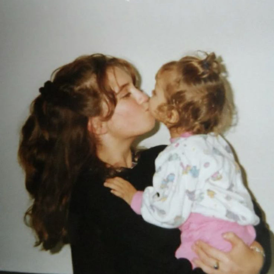Image d’une mère embrassant son enfant sur le nez, illustrant la conclusion du rituel par un moment complice et affectueux.